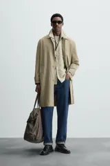 Gabardina color beige de corte recto, con cuello solapa, cierre frontal con botones, bolsillos laterales y puños ajustables con trabilla.
