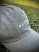 Gorra de gabardina color gris oscuro con visera curva y logo de la marca bordado en blanco en el frente.