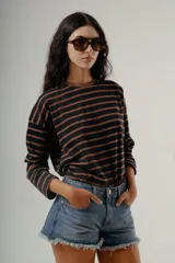 Camiseta de manga larga, corte holgado, con cuello redondo y estampado de rayas horizontales en tonos negro y marrón.