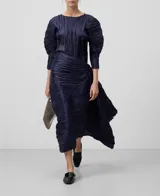 Blusa azul marino con textura arrugada, cuello barco y mangas largas abullonadas.