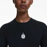 Colgante con cristal transparente talla octogonal, engarzado en metal plateado y cordón negro ajustable.