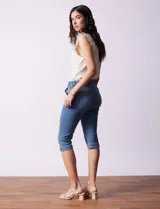 Pantalón capri blanco de algodón elastizado. Pretina con pasadores, botón y cierre. Delantera con bolsillos. Trasera con bolsillos simulados.