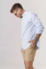 Bermuda color beige de lino, corte recto y largo a la rodilla.