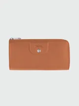 Billetera clásica Longchamp de cuero color marrón con cierre de cremallera y broche a presión.