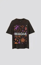Remera negra con efecto gastado, de corte oversize y manga corta. Estampado en la espalda con dibujos de estilo esotérico en tonos violeta y naranja, y la palabra 'MAGIA' en blanco.