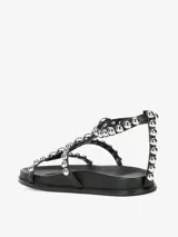 Sandalias blancas con tachas plateadas, forro y suela sintética, con cierre de velcro.