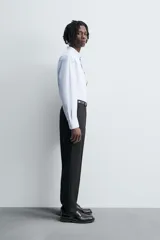 Camisa de algodón color celeste claro, corte regular fit, con cuello abotonado (button-down), manga larga con puño abotonado y bolsillo de parche en el pecho izquierdo.