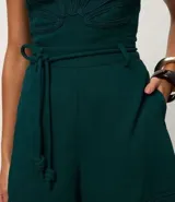 Short de mujer confeccionado en viscolino color verde oscuro. Presenta cintura elástica con lazo de ajuste y detalle de cuerda, y terminación con pespuntes en el ruedo.