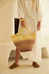 Bolso tipo tote confeccionado en soga de algodón color crudo, con asas de hombro y broche de bronce.