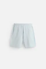 Bermuda relaxed fit de algodón con elasticidad, color celeste. Tiene cintura elástica ajustable con cordón, bolsillos laterales y bolsillo trasero de plastrón.