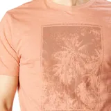 Remera color salmón con estampa rectangular en el frente con una imagen de palmeras y texto en la parte inferior.