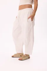 Pantalón blanco de tela ligera con cintura elastizada, calce relaxed y bolsillos laterales.
