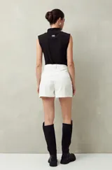 Short blanco de tiro alto con bolsillos delanteros con solapa y botones a la vista.