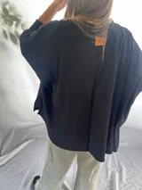 Remera blanca de corte amplio y mangas largas.