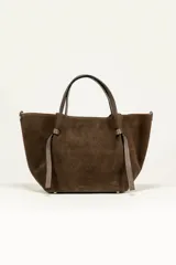 Cartera tote de gamuza marrón con doble asa corta y tiras decorativas anudadas en los laterales.
