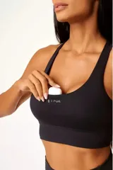 Top deportivo negro con diseño racerback, bolsillo trasero y bolsillo interno en el forro frontal.