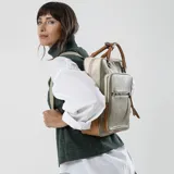 Mochila combinada en tres tonos de símil cuero: marrón, beige y negro. Tiene doble bolsillo frontal, asa de mano y correas regulables. En su interior tiene dos bolsillos con cierre y uno abierto con división para celular.