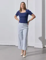 Pantalón wide leg a rayas verticales celestes y blancas, con pretina con botón y bolsillos simulados.
