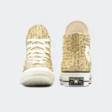 Championes Converse Chuck 70 de caña alta, color dorado brillante con glitter. Cierre con cordones blancos y suela de goma blanca con líneas negras.