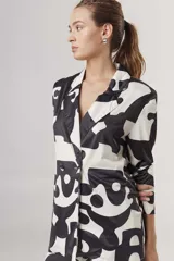 Blazer con estampado abstracto en blanco y negro, con solapas de muesca, cierre con dos botones y corte recto.