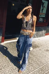 Pantalón cargo oversize de jean con múltiples bolsillos funcionales y detalles metálicos en bronce.