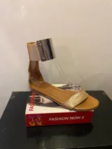 Sandalias Sons + Lips color cuero con tira delantera con textura de piel de serpiente dorada, pulsera tobillera plateada y cierre con hebilla.