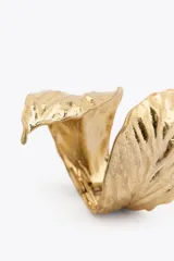 Pulsera rígida dorada con forma de hoja.