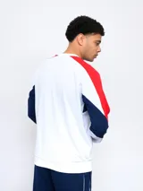 Buzo de felpa azul marino, con mangas largas, cuello redondo y puños acanalados. Presenta cortes en blanco y rojo en la parte superior, logo de Umbro bordado en el pecho y escudo del Club Nacional de Football.