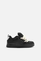 Zapatillas negras de skate con cordones gruesos tipo cuerda, lengüeta acolchada y suela con volumen.