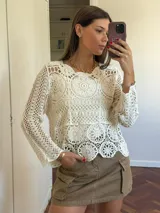 Blusa color crudo calada de crochet, de mangas largas y cuello redondo.