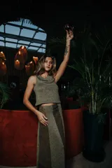 Falda larga de cuero marrón con paneles verticales en color dorado.