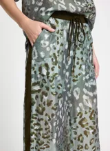 Pantalón de tiro alto confeccionado en tejido similar al lino con estampado animal, cintura elástica con cordón, cuatro bolsillos, banda lateral, bajos ajustables y acabado pespunteado.