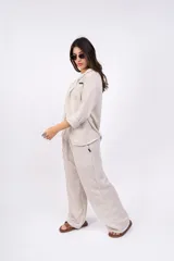 Camisa a rayas verticales color beige y blanco, con cuello clásico, cierre frontal con botones y mangas largas.