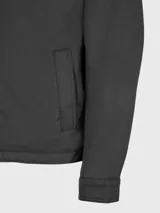 Campera negra con cuello camisero, cierre frontal con cremallera, dos bolsillos laterales y logo de Tommy Hilfiger bordado en el pecho.