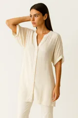 Túnica color crudo de algodón, holgada, con botones, lazo y cuello profundo.