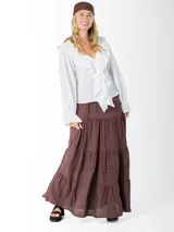 Falda larga marrón de estilo campesina, confeccionada en lino rayón liviano, con corte en capas y detalles de costuras verticales.