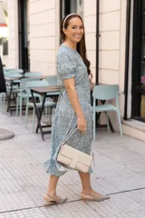 Vestido midi de poliéster y algodón, color verde azulado con estampado floral blanco, corte recto, mangas cortas con volados y cuello redondo.