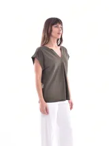 Blusa blanca de corte holgado, con cuello en V y mangas cortas.