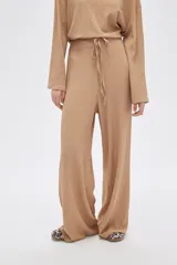 Pantalón de calce ancho y tiro alto, color beige con textura.