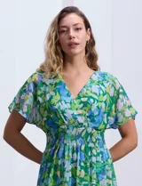 Vestido largo de gasa estampada con flores en tonos verde y azul, escote en V delantero y trasero, corte en la cintura con punto smock y mangas cortas.