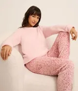 Conjunto de pijama largo de fleece, compuesto por una blusa lisa de manga larga y cuello redondo, y un pantalón con cintura elástica y estampado animal print de leopardo.