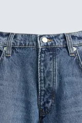 Pantalón de jean negro de corte amplio, estilo balloon fit, con cinco bolsillos y cierre frontal con botones.