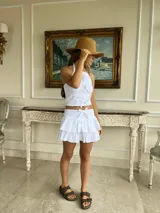 Minifalda blanca con volados en capas, talle alto con detalle de lazo central.