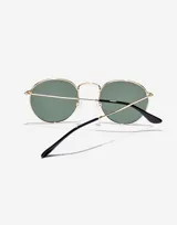 Lentes de sol Hawkers modelo Moma Midtown, unisex, con montura metálica dorada de forma ovalada y lentes polarizadas verdes.