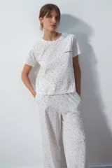 Conjunto de pijama blanco con estampado de lunares rojos, compuesto por una remera de mangas cortas y un pantalón palazzo.
