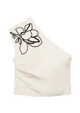 Top de algodón color crema, con cuello asimétrico, detalle de bordado floral en el hombro y frunces laterales. Cierre lateral con cremallera.