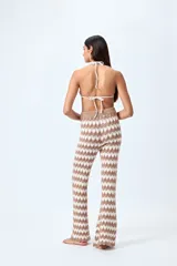 Pantalón tejido con motivo zigzag en tonos beige y blanco, de corte flare y cintura elastizada.