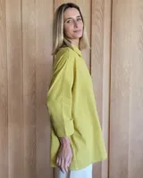 Camisa celeste de corte amplio, con cuello clásico y mangas largas.