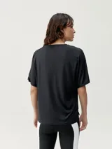 Camiseta deportiva blanca de corte holgado y manga corta, confeccionada en tejido técnico fluido.