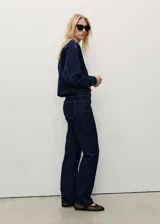 Pantalón de jean azul oscuro de corte recto, tiro medio y largo hasta el tobillo.